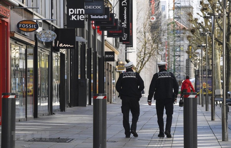Nhân viên an ninh tuần tra gần Koeniggstrasse, một khu phố thương mại sầm uất ở Stuttgart, miền Nam Đức trong bối cảnh lệnh hạn chế được ban bố do dịch COVID-19. 