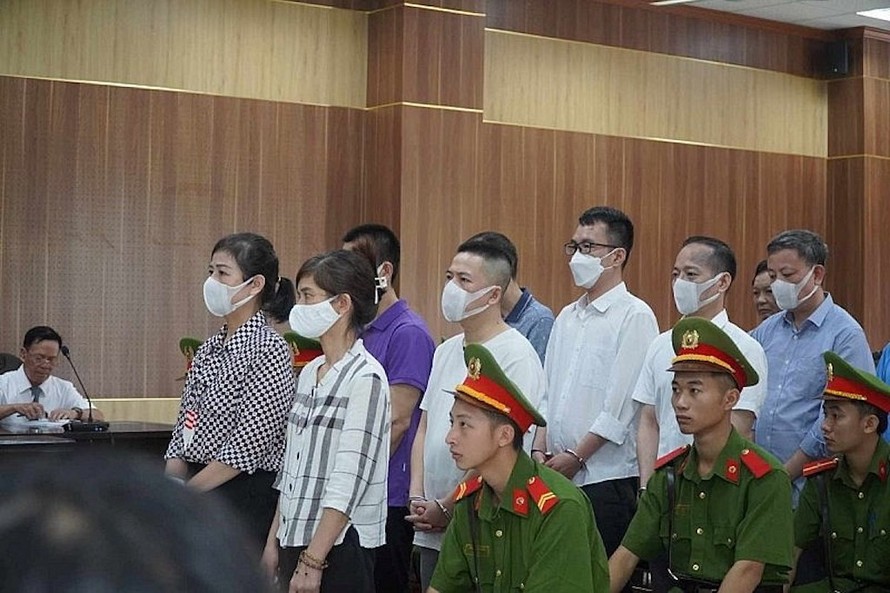Cựu Giám đốc Sở Giáo dục và Đạo tạo Thanh Hóa Phạm Thị Hằng (áo kẻ) cùng 11 thuộc cấp tại phiên tòa sơ thẩm sáng ngày 20/7.