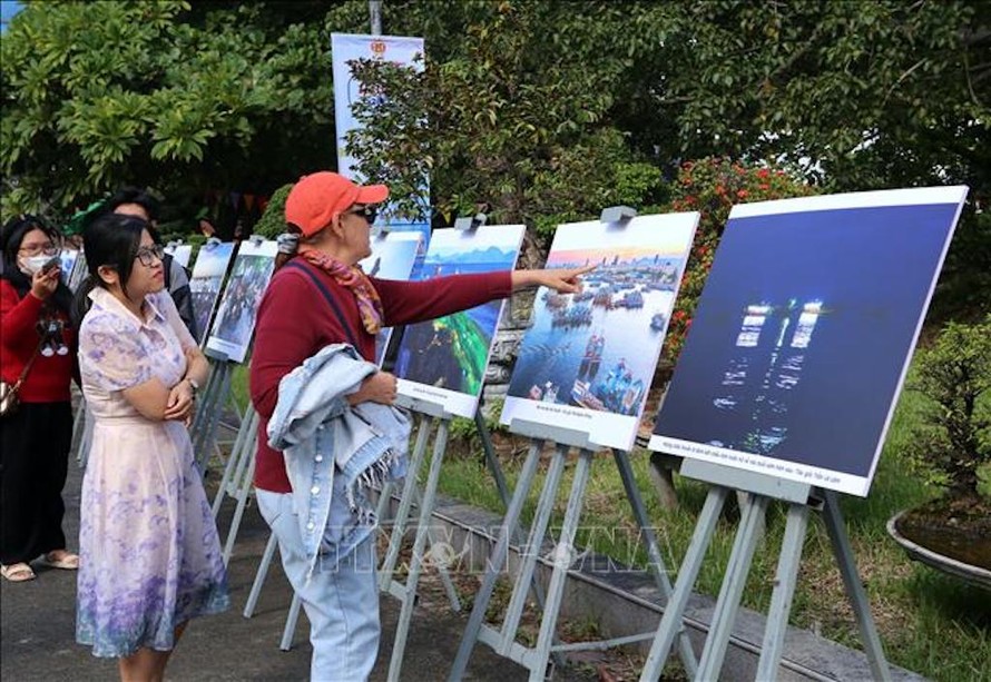 Khách du lịch quốc tế tham quanTriển lãm ảnh "Chuyện làng biển" tại ngày hội. 