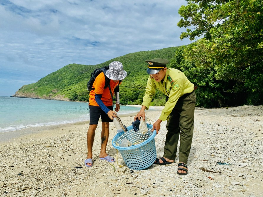 Du khách và lực lượng kiểm lâm Vườn Quốc gia Côn Đảo cùng thu gom rác thải nhựa từ đại dương trôi dạt vào hòn Bảy Cạnh.