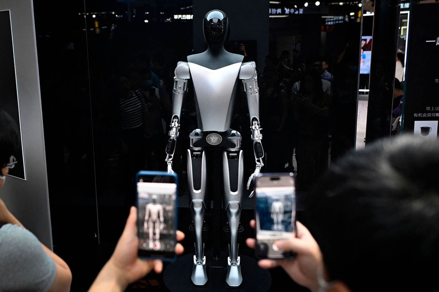 Khách tham quan chụp ảnh robot Tesla trưng bày tại Hội nghị Trí tuệ Nhân tạo Thế giới (WAIC) ở Thượng Hải, ngày 6/7/2023. Ảnh: Sixth Tone