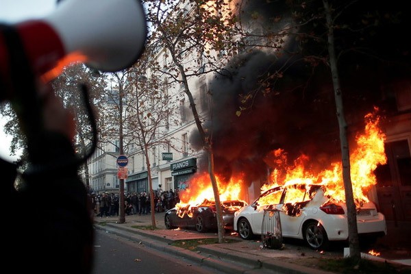 Những người biểu tình quá khích đốt phá xe hơi trên đường phố Paris. Ảnh: EPA