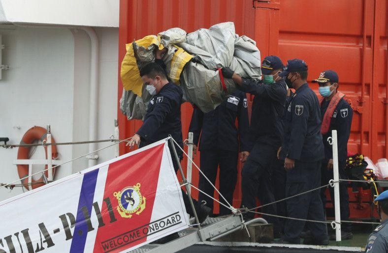 Lực lượng cứu hộ Indonesia tiếp nhận các bộ phận cơ thể, quần áo và mảnh kim loại được vớt lên khỏi biển Java vào sáng sớm 10/1, một ngày sau khi chiếc Boeing 737-500 chở 62 người trên khoang gặp nạn ngay sau khi cất cánh từ Jakarta. Ảnh: AP 