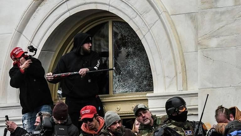 Nhiều người biểu tình có vũ trang đang phá cửa Điện Capitol, Mỹ vào ngày 6/1. Ảnh: Reuters.