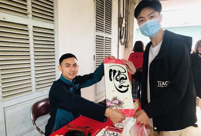 Hoàng Ðạt viết tặng thư pháp cho bạn trẻ Ðà Nẵng vừa hiến máu tại Chủ nhật Ðỏ 2021. Ảnh: Lãnh Ðoàn/Tiền Phong 