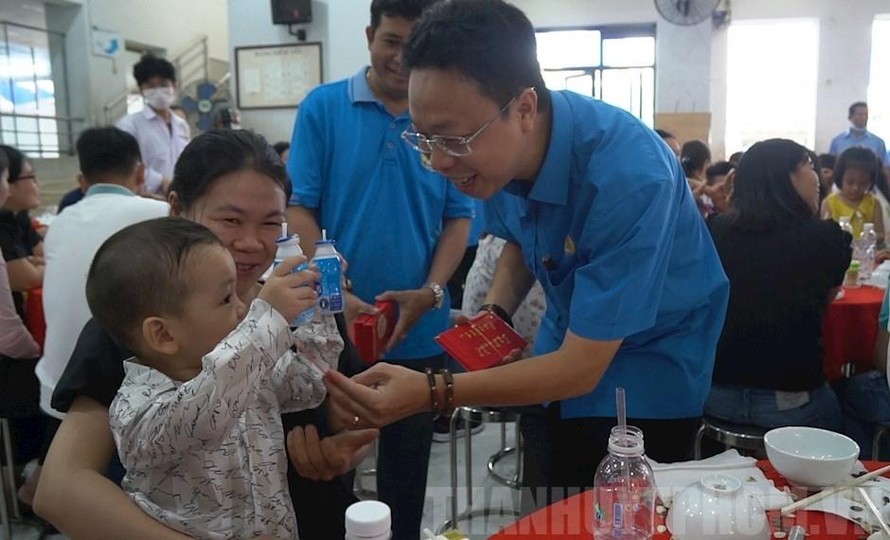 Đồng chí Nguyễn Thành Đô, Trưởng Ban Chính sách pháp luật Liên đoàn Lao động Thành phố lì xì cho con các gia đình công nhân lao động tham dự Chương trình “Tết sum vầy” năm 2021. (Ảnh: Đảng bộ TP HCM) 