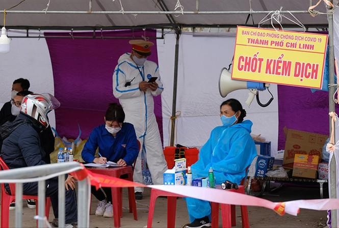 Người dân khai báo y tế tại một chốt kiểm dịch ở Chí Linh. Ảnh: Hoàng Mạnh Thắng/Tiền Phong