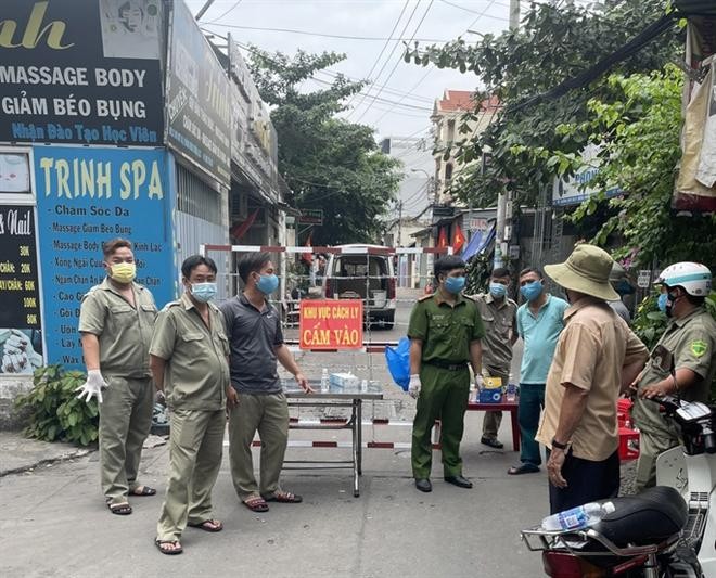 Lực lượng chức năng phong tỏa một con hẻm ở phường Đông Hưng Thuận, quận 12, TP HCM. (Ảnh: NLĐ)