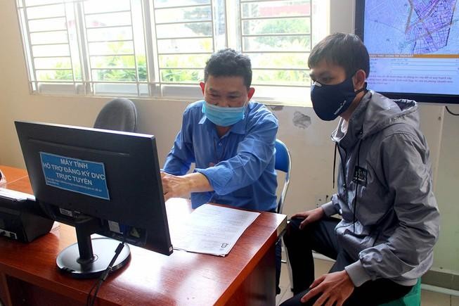 Cán bộ tại bộ phận một cửa quận Bình Tân đang hướng dẫn người dân cách làm thủ tục bằng hình thức trực tuyến. (Ảnh: Lê Thoa/Báo Pháp luật TP HCM)