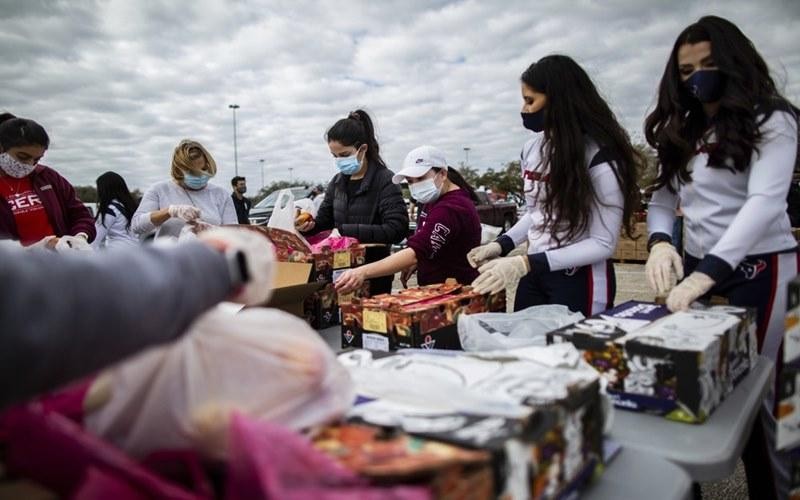 Các tình nguyện viên đeo khẩu trang trong lúc phân phối thực phẩm cứu trợ người dân tại bang Texas, Mỹ, ngày 21-2. (Ảnh: AP) 