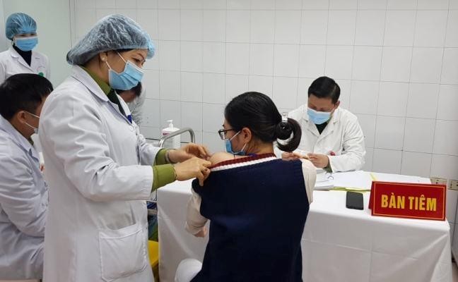 Một nữ tình nguyện viên đang được bác sĩ tiêm vắc-xin COVID-19 liều cao nhất. (Ảnh: Báo điện tử Đảng Cộng sản)