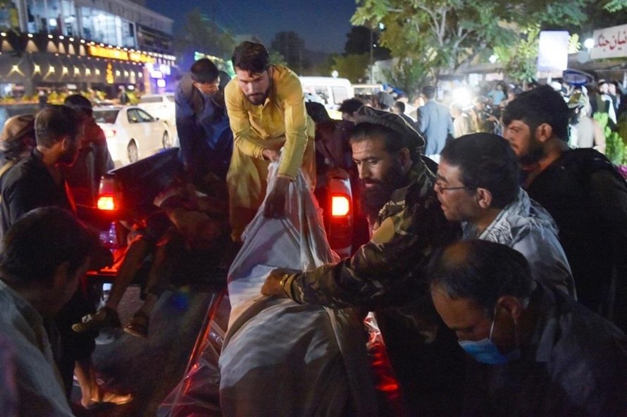 Các tình nguyện viên và nhân viên y tế nâng thi thể từ một chiếc xe bán tải bên ngoài bệnh viện ở thủ đô Kabul sau hai vụ nổ. (Ảnh: VnExpress)