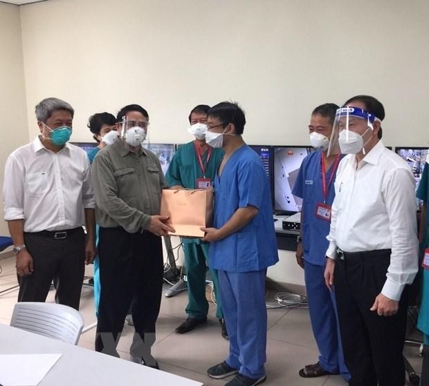 Thủ tướng Phạm Minh Chính thăm hỏi và tặng quà các bác sỹ đang tham gia điều trị bệnh nhân COVID-19 tại Bệnh viện dã chiến Hồi sức tích cực Becamex tỉnh Bình Dương. (Ảnh: TTXVN)