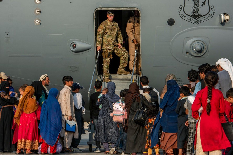 Lính Mỹ chuẩn bị cho người tị nạn Afghanistan lên máy bay tại một căn cứ không quân ở Qatar.