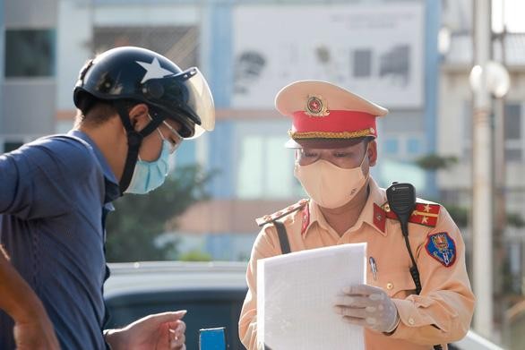 Cảnh sát giao thông kiểm tra giấy đi đường của người dân từ "vùng xanh" vào "vùng đỏ" ở Hà Nội. (Ảnh: Tuổi trẻ) 