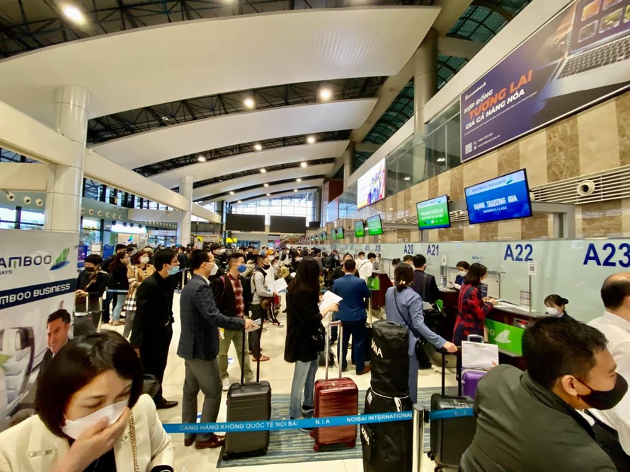 Hành khách xếp hàng trước các quầy làm thủ tục của Bamboo Airways tại sân bay Nội Bài sáng 23-10-2021.