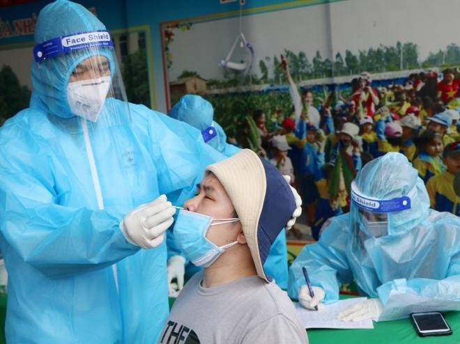 Nhân viên y tế lấy mẫu xét nghiệm sang lọc cho người dân phường Gia Cẩm, thành phố Việt Trì. Ảnh: Trung Kiên - TTXVN
