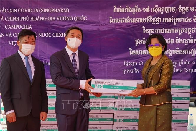 Quốc vụ khanh Bộ Y tế Campuchia Or Vandine (phải) bàn giao số vaccine cho Thứ trưởng Bộ Y tế Trần Văn Thuấn. 
