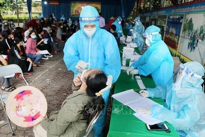 Nhân viên y tế lấy mẫu xét nghiệm sàng lọc COVID-19 cho người dân phường Gia Cẩm, thành phố Việt Trì. Ảnh tư liệu: Trung Kiên/TTXVN