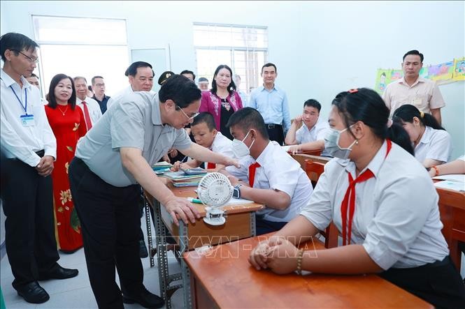 Thủ tướng Phạm Minh Chính thăm, động viên học sinh Trường nuôi dạy trẻ em khuyết tật Bến Tre. Ảnh: Dương Giang/TTXVN