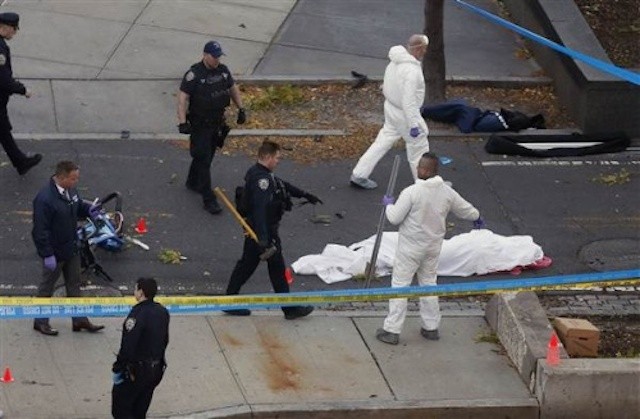 Cảnh sát bên cạnh thi thể phủ vải trắng tại hiện trường vụ khủng bố ở thành phố New York hôm 31/10. Ảnh: Reuters.