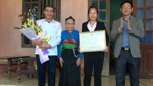 Ông Tuấn (bìa phải) trao giấy khen và tiền thưởng của huyện cho gia đình thủ môn Tiến Dũng