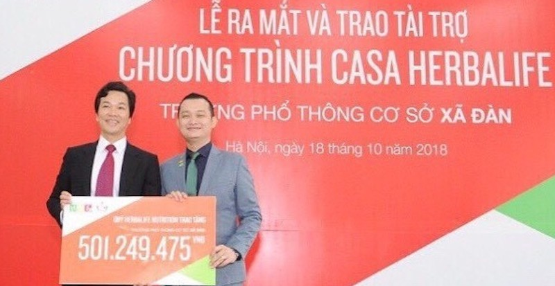 Ông Phạm Tường Huy (Tổng giám đốc Herbalife Việt Nam) trao tặng bảng tượng trưng giá trị tài trợ của chương trình Casa Herbalife cho thầy Phạm Văn Hoan (Hiệu trưởng trường PTCS Xã Đàn).