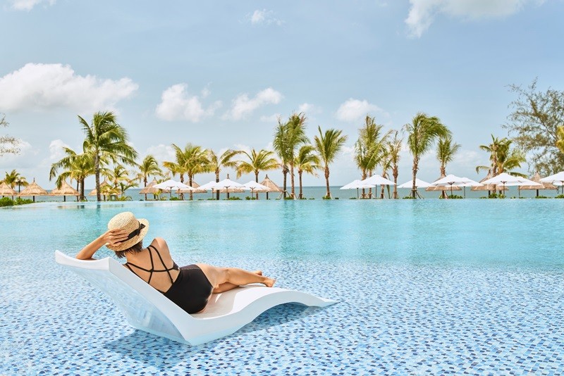 Khách hàng tận hưởng cảm giác thư thái bên bể bơi tuyệt đẹp trong khu nghỉ dưỡng Mövenpick Resort Waverly Phú Quốc
