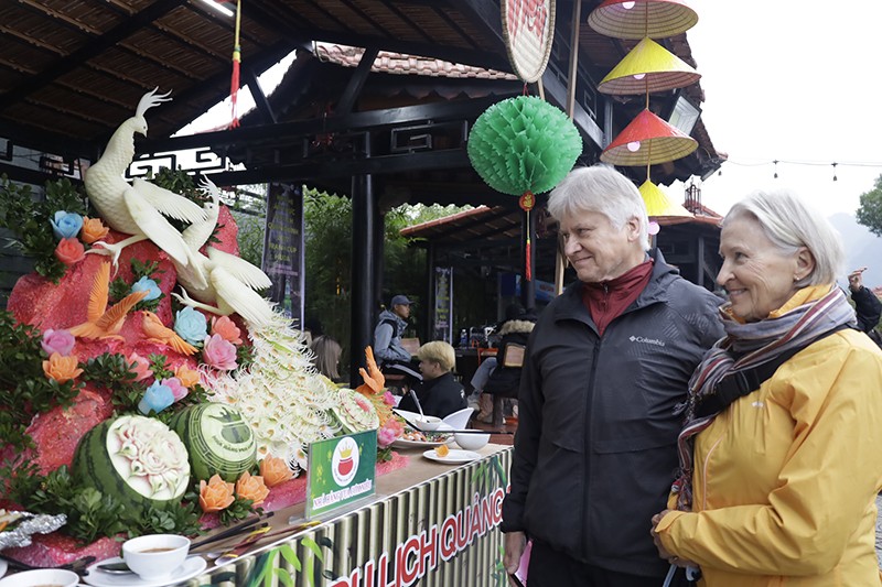  Khách nước ngoài hào hứng tham quan gian hàng các món ăn tại Hội thi Ẩm thực Du lịch Quảng Bình 2022 (nguồn: Báo Quảng Bình).