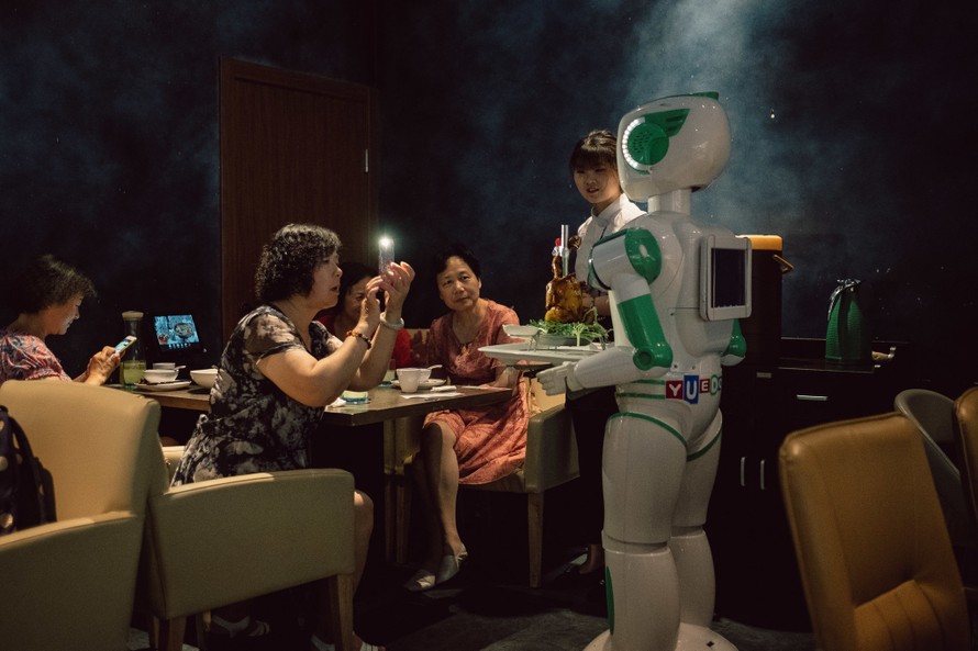 Robot phục vụ vẫn cần nhân viên hộ tống tại nhà hàng Robot Magic ở Thượng Hải, Trung Quốc. (Nguồn: NYTimes).