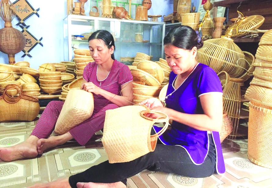 Các thành viên của Hợp tác xã Mây tre đan Bao La đang sản xuất sản phẩm phục vụ dịp Tết nguyên đán.
