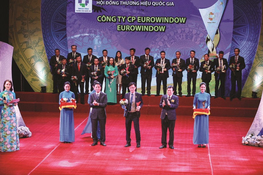 Phó Thủ tướng Trịnh Đình Dũng và Bộ trưởng Bộ Công Thương Trần Tuấn Anh trao biểu trưng THQG 2018 cho đại diện Công ty CP Eurowindow.