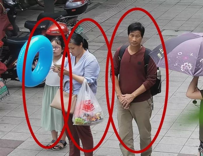 Bức ảnh trích xuất từ camera an ninh cho thấy cô bé Zhang Zixin bị 2 người lớn dẫn đi. (Ảnh: Getty).