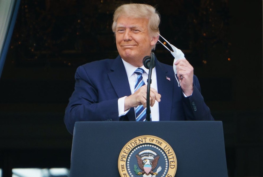 Tổng thống Trump tháo phăng chiếc khẩu trang trong lúc phát biểu tại Nhà Trắng hôm 10/10. (Nguồn: AP).
