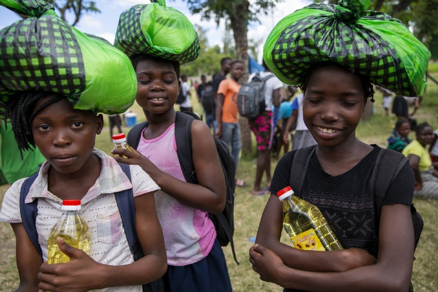 Các nữ sinh ở Beira (Mozambique) lấy khẩu phần ăn về nhà trước khi trường học đóng cửa vào tháng Tư.(Ảnh: Karel Prinsloo/Arete/UN Mozambique).