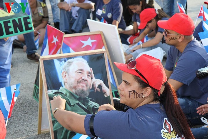 Người dân Cuba cầm theo di ảnh của Fidel Castro và viết tên ông lên mặt