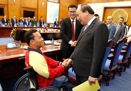 Thủ tướng Nguyễn Xuân Phúc trò chuyện thân mật với vận động viên khuyết tật Lê Văn Công