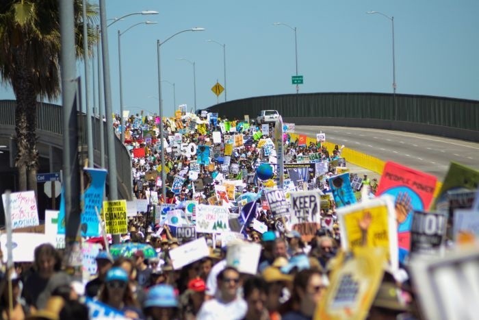 Người biểu tình giơ cao biểu ngữ, diễu hành dọc đường cao tốc ở thành phố Los Angeles, bang California, bờ tây nước Mỹ. Ảnh: A
