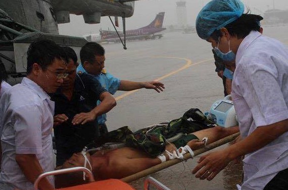 Các bác sĩ đưa anh Giang ra khỏi trực thăng lên xe cấp cứu để về bệnh viện. Ảnh: H.P
