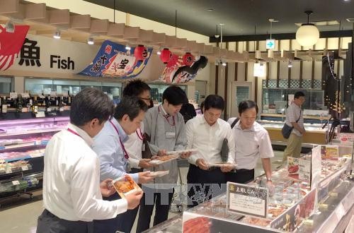 Đại diện Bộ Công Thương và cán bộ phụ trách siêu thị AEON Nhật Bản xem mặt hàng cá tra Việt Nam. Ảnh: Thành Hữu/Phóng viên TTXVN tại Nhật Bản