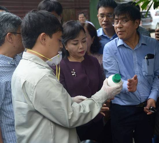 Bộ trưởng Bộ Y tế Nguyễn Thị Kim Tiến kiểm tra loại thuốc phun để diệt muỗi, đảm bảo hạn sử dụng, pha liều lượng đúng quy định. Ảnh: BYT