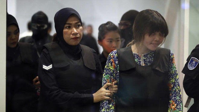 Đoàn Thị Hương (phải) được cảnh sát hộ tống tới ga KLIA2 tại sân bay ở Sepang, Malaysia, ngày 24/10. Ảnh: AP