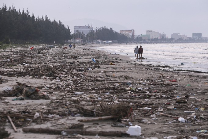 Người dân địa phương "lội" giữa bãi rác để đi dạo ven bãi biển