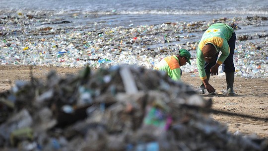 Các nhân viên vệ sinh thu nhặt rác trên bãi biển Kuta ở đảo Bali - Indonesia Ảnh: SONNY TUMBELAKA 