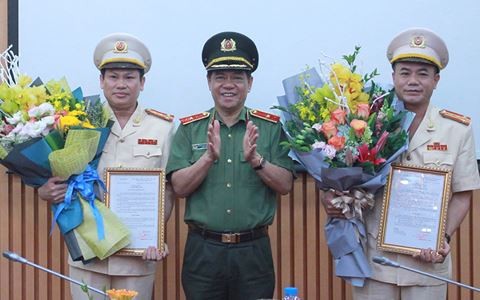 Thiếu tướng Đoàn Duy Khương, Giám đốc Công an Thành phố trao Quyết định bổ nhiệm chức vụ cho Đại tá Nguyễn Văn Viện (trái) và Đại tá Nguyễn Thanh Tùng (phải)