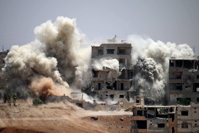 Khói bốc lên sau một đợt không kích ở thành phố Daraa. (Nguồn: AFP/TTXVN)