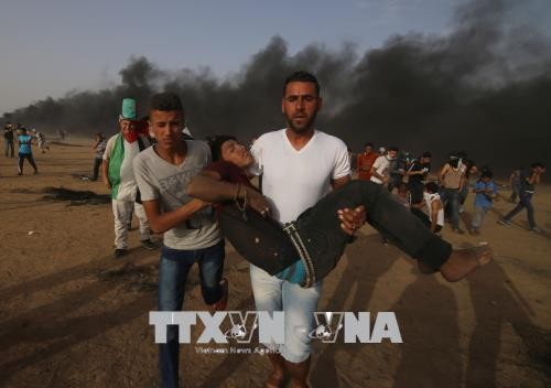 Người biểu tình Palestine bị thương trong cuộc xung đột với quân đội Israel gần khu vực biên giới Dải Gaza với Israel ngày 25/5. Ảnh: THX/TTXVN