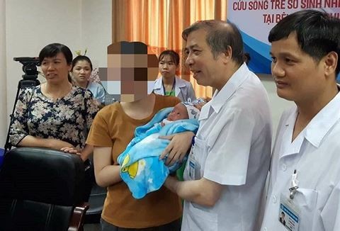 Giám đốc BV Phụ sản Trung ương Vũ Bá Quyết chung vui với mẹ bệnh nhi Nguyễn Vân Đ. trong ngày cháu bé được xuất viện