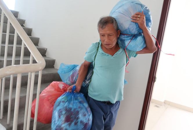 Ông Trần Quang Huệ mang hành lý ra khỏi chung cư