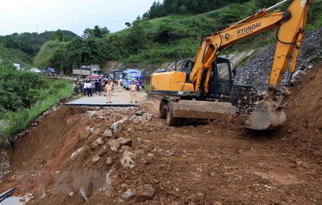 Công ty quản lý và xây dựng cầu đường 3 khẩn trương khắc phục đoạn đường bị đứt do mưa lũ gây ra tại km 369, quốc lộ 32 huyện Tân Uyên đi Than Uyên. (Ảnh: Quý Trung/TTXVN)